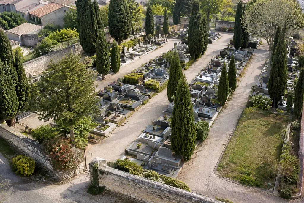 Une parcelle libre apparaît entre les allées d’un cimetière de petite ville.